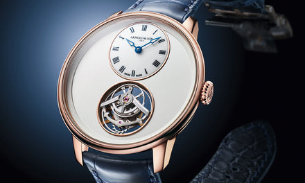 Luxury wristwatch with a white dial, Roman numerals, and an exposed tourbillon, on a blue leather strap.