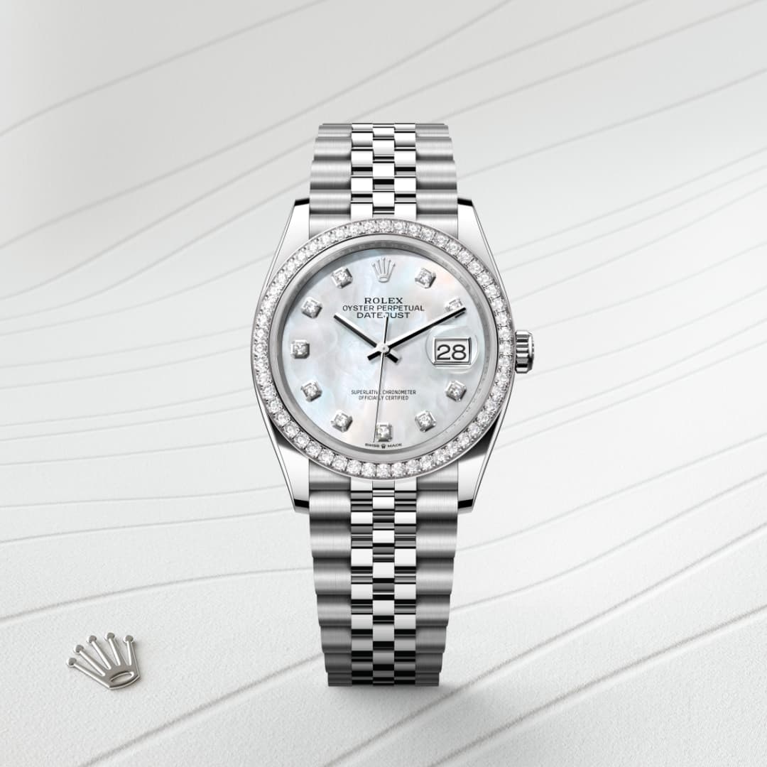 A silver Rolex Datejust watch with diamond markers on a patterned white surface, crown logo beside it.