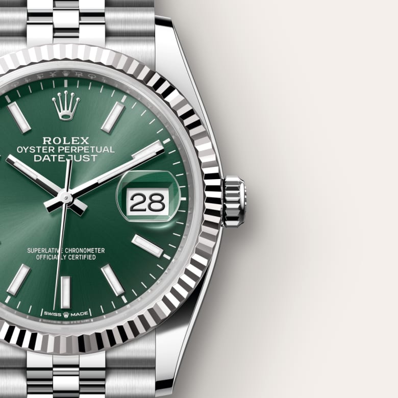 Close-up of a Rolex Datejust watch with a green dial and silver metal band, date displayed at 3 oclock.