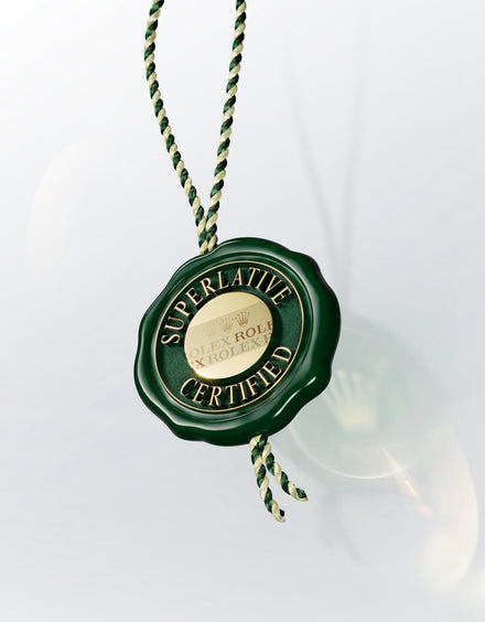 A green Rolex hang tag with Superlative Certified and a gold center, hanging by a green and white string.