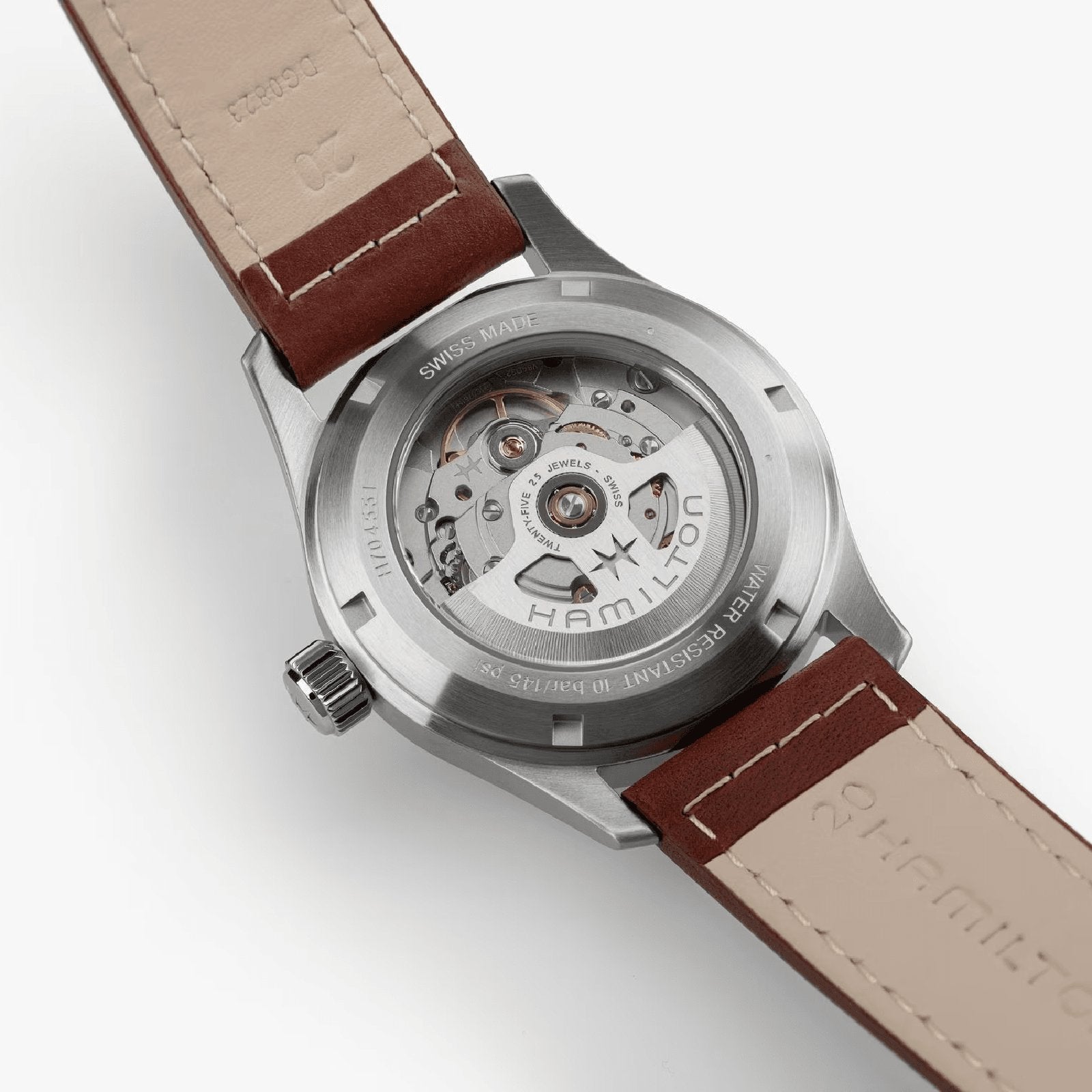 Back view of the Hamilton Khaki Field Auto 38mm, revealing its H-10 automatic movement through a transparent caseback, brown leather straps, and visible engraved markings.