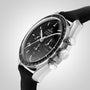 A close-up of the OMEGA Speedmaster Moonwatch Professional with a black dial, chronograph functions, and a black fabric strap—an iconic tribute to the first watch on the moon—set against a light gray background.