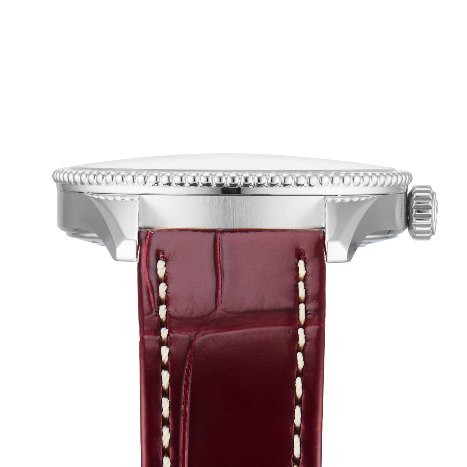 Side view of the Breitling Navitimer 32, featuring a silver case, textured bezel edge, and brown leather strap with white stitching, powered by the precise Breitling Calibre 77 SuperQuartz™ movement.