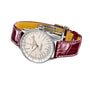 The Breitling Navitimer Automatic 36 wristwatch features a white dial, 36mm stainless steel case, and burgundy leather strap, displayed at an angle on a white background.