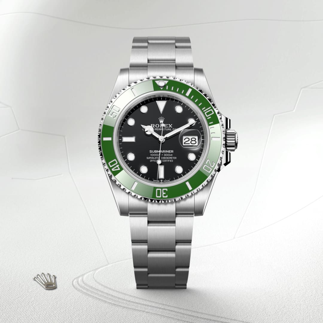 A stainless steel Rolex Submariner watch with a green bezel and black dial displayed on a textured surface.